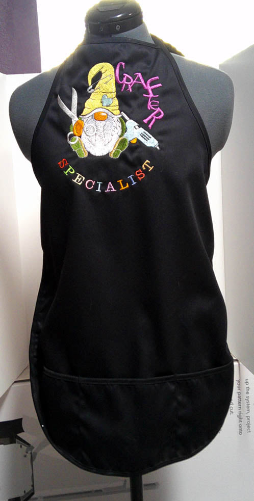 Black adult crafter apron with front pockets and embroidered gnome on the front